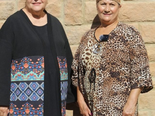Two white ladies standing next to each other