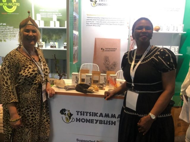 Two ladies standing in front of a table